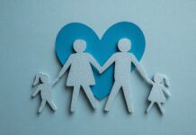 Family Health Protection: Planning for Future Needs Paper cutout of a family holding hands with a blue heart in the background