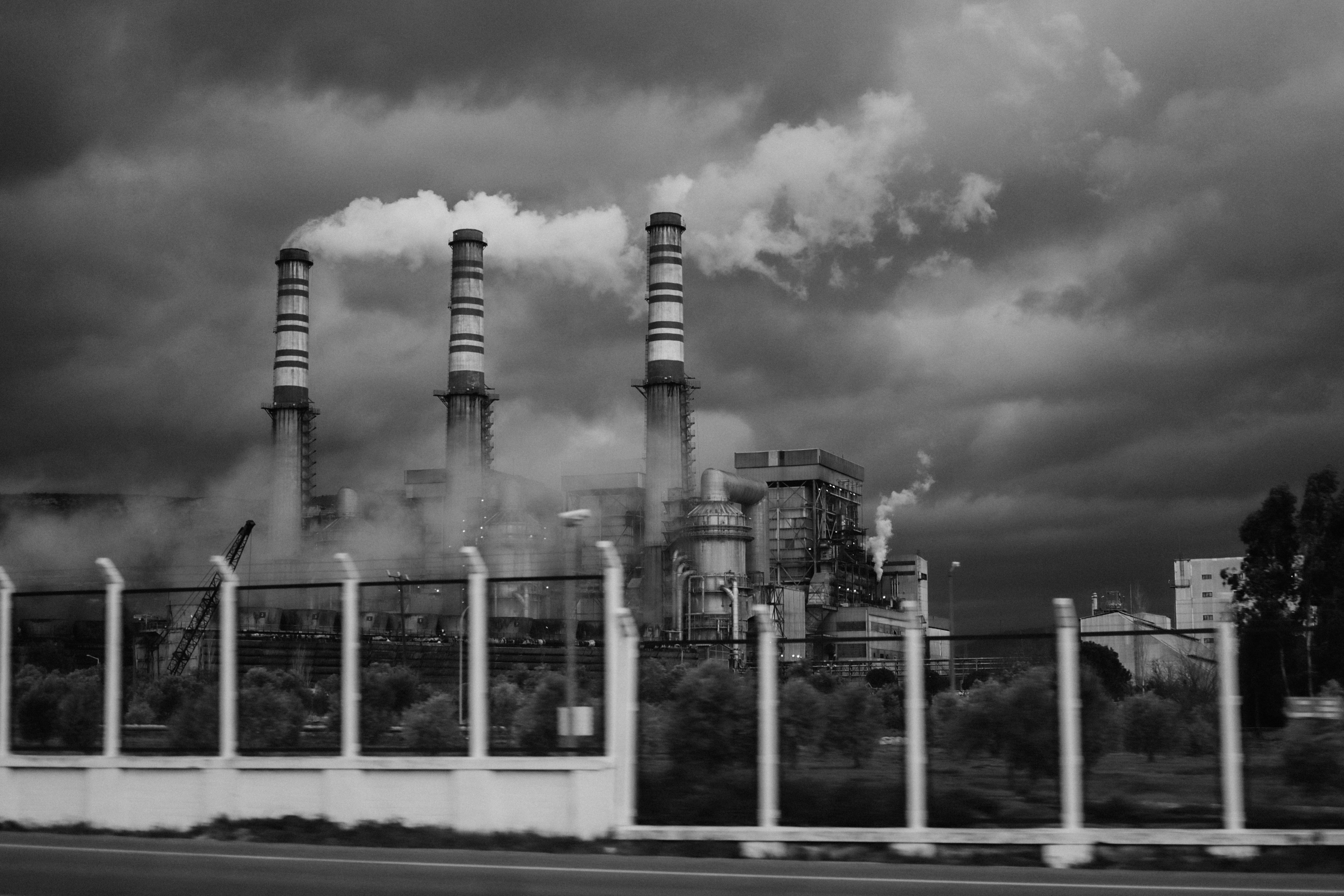 Black-and-white photo of a factory emitting smoke from industrial pollution