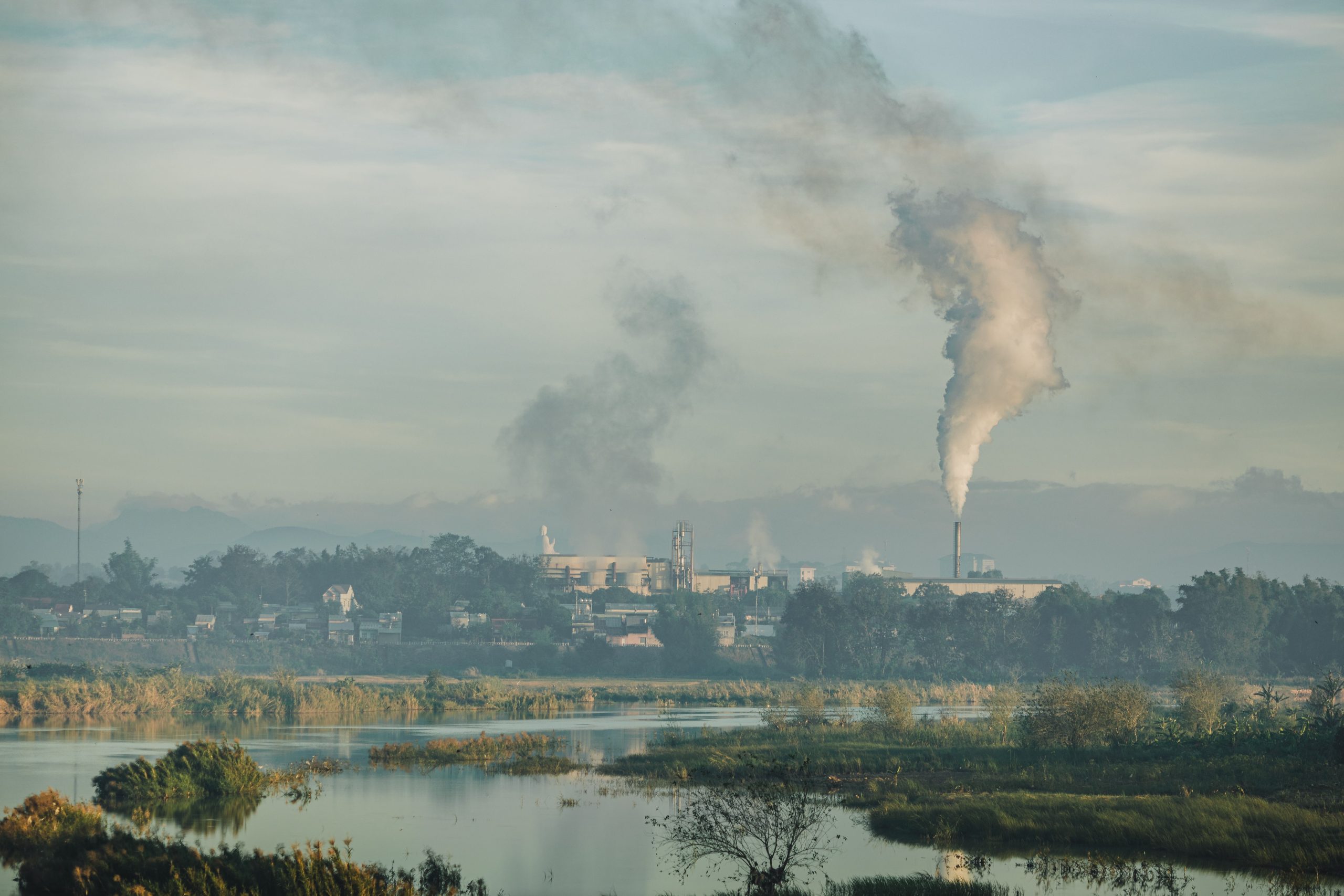 rural-community-factory-pollution-prostate-cancer Factory emitting smoke over a natural rural landscape near an Indigenous community