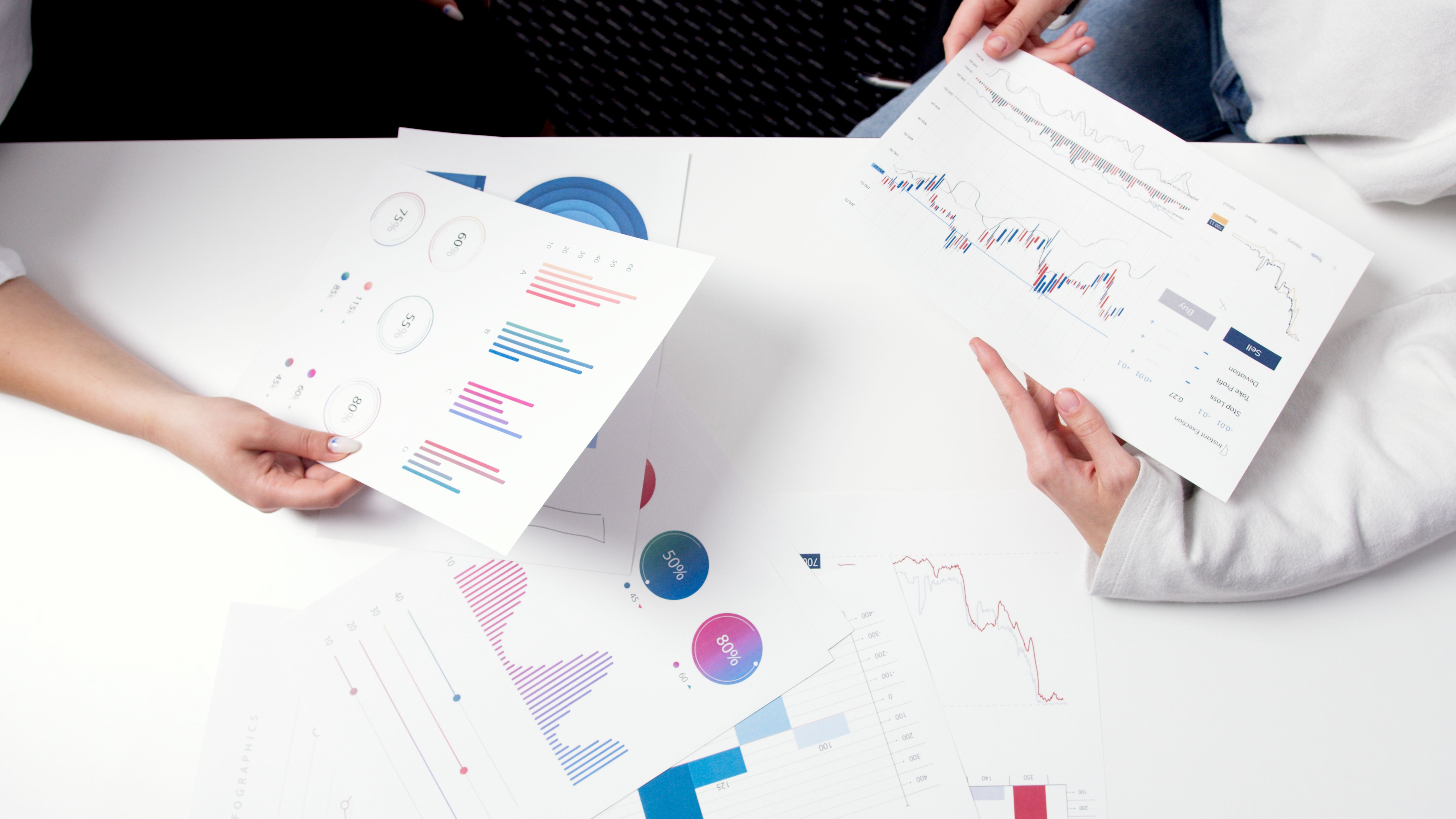 Hands holding charts and graphs during a meeting about financial analysis and investment strategy